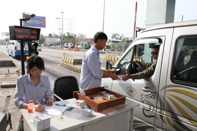 Nhân viên trạm thu phí phải mở thêm làn xe ra và thu phí thủ công để giải phóng nhanh lượng xe ùn ứ trong đường cao tốc TP.HCM-Trung Lương