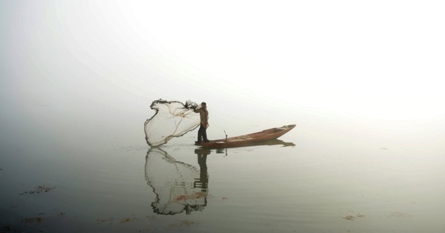 Ngư dân thả lưới trên hồ Dal trong một ngày sương mù dày đặc ở Srinagar, Ấn Độ.
