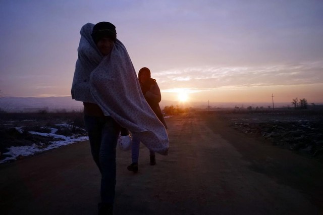 Những người di cư cố gắng giữ ấm trong hành trình vượt biên từ Macedonia sang thị trấn Miratovac, Serbia.