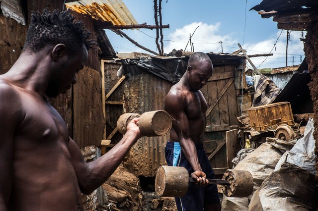 
Những người đàn ông tập thể hình với dụng cụ tự chế tại một khu ổ chuột ở Kibera, Kenya.
