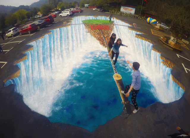 Mọi người đi trên bức tranh 3D được vẽ tại một bãi đỗ xe ở thành phố Trường Sa, tỉnh Hồ Nam, Trung Quốc.