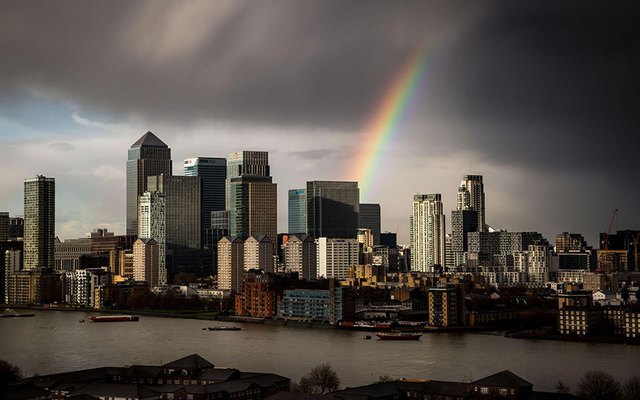 Cầu vồng xuyên qua đám mây đen trên bầu trời thành phố London, Anh.