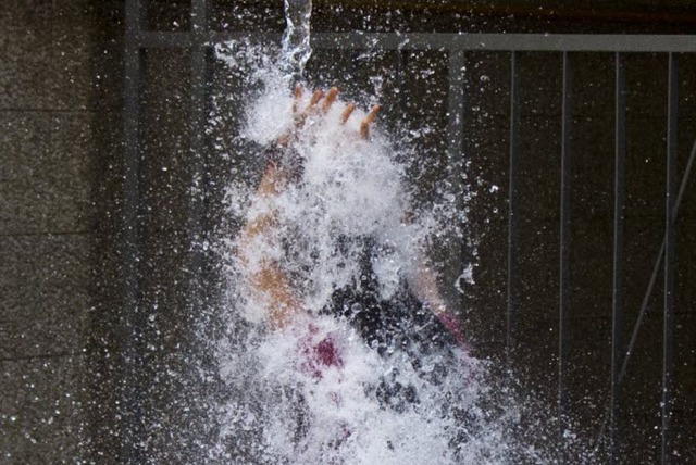 Một phụ nữ bị đổ nước từ trên cao như một cách để chào đón năm mới ở Montevideo, Uruguay.