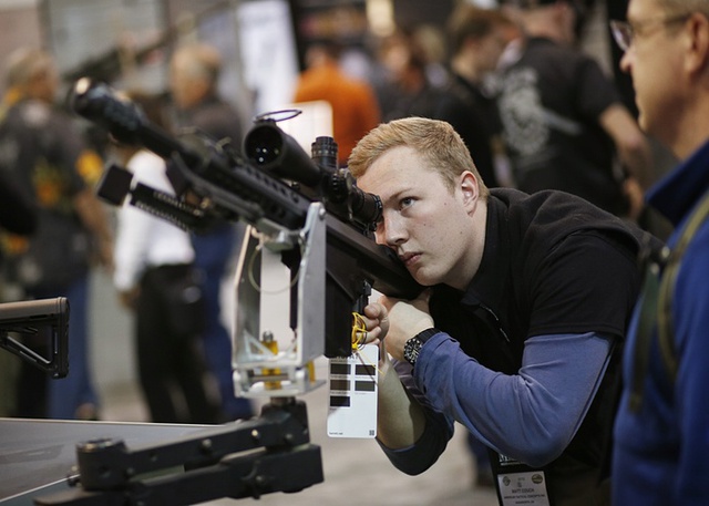Du khách kiểm tra một khẩu súng trường tại triển lãm súng ở thành phố Las Vegas, bang Nevada, Mỹ.