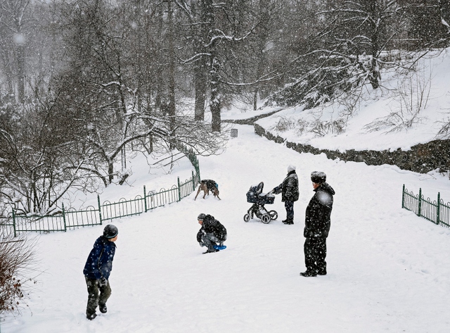 Một gia đình chơi đùa dưới mưa tuyết ở thành phố Kiev, Ukraine.