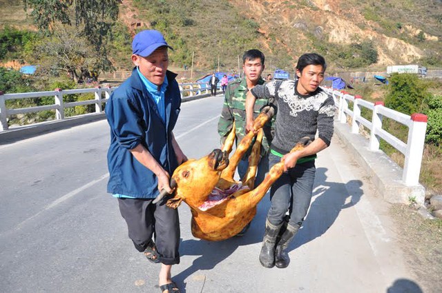 Người dân khiêng con trâu mới mổ sạch ra gian hàng để bày bán bên quốc lộ 4D.