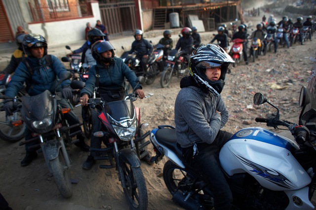 Những người đi mô tô xếp thành hàng dài chờ đổ xăng tại thành phố Kathmandu, Nepal.