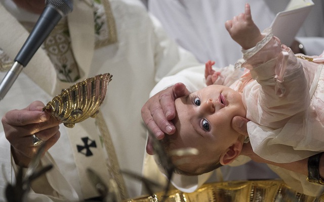 Giáo hoàng Francis làm lễ rửa tội cho một em bé tại nhà thờ Sistine ở Vatican.