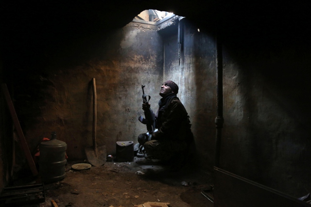 Một chiến binh quân nổi dậy ngồi dưới hầm ở vùng ngoại ô thủ đô Damascus, Syria.