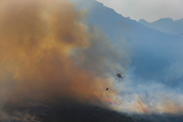 Trực thăng cứu hỏa thả nước để cố gắng dập tắt cháy rừng trên núi ở thành phố Cape Town, Nam Phi.