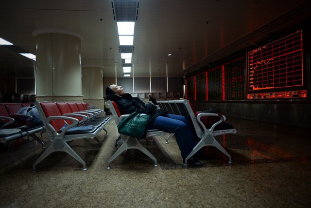 
Một nhà đầu tư ngủ gục trước màn hình hiển thị chuyển động của thị trường chứng khoán tại một công ty ở Bắc Kinh, Trung Quốc.
