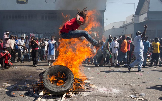 Người biểu tình nhảy qua một đống lửa trên đường trong cuộc biểu tình phản đối chính phủ ở Port-au-Prince, Haiti.
