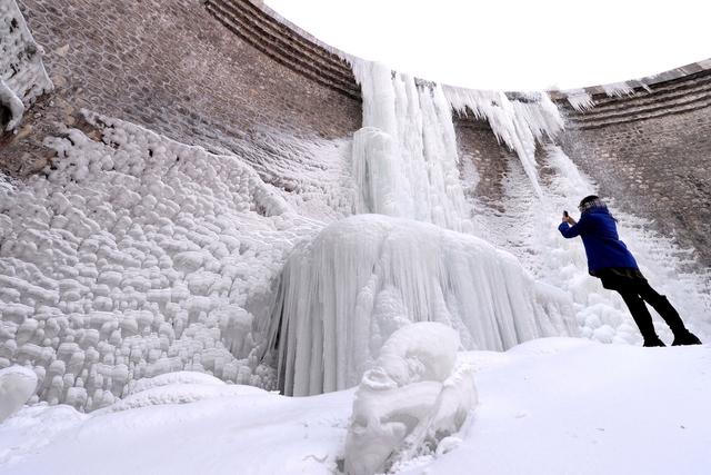 Du khách chụp ảnh thác nước đóng băng ở thành phố Nhật Chiếu, Trung Quốc.