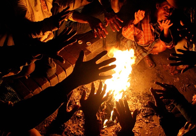 Người dân sưởi ấm quanh đống lửa khi nhiệt độ hạ thấp vào mùa đông ở thành phố Dhaka, Bangladesh.