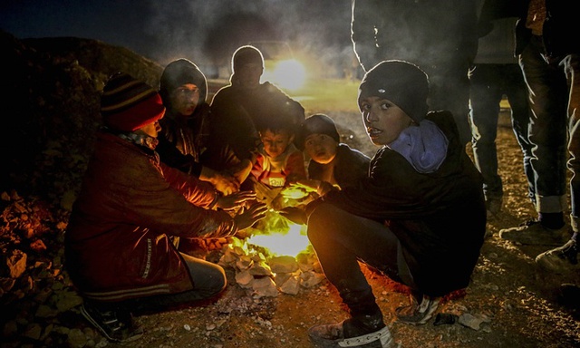 Mọi người sưởi ấm quanh đống lửa tại một trại tị nạn ở ngoại ô thành phố Aleppo, Syria, giáp biên giới với Thổ Nhĩ Kỳ.