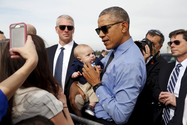 Tổng thống Barack Obama bế một em bé trước khi lên chuyên cơ Air Force One, khởi hành từ sân bay ở bang California.