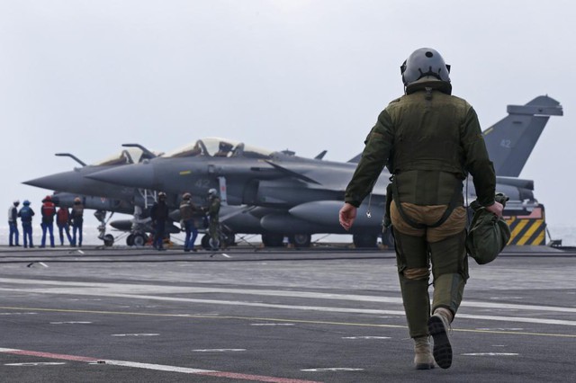 Phi công đi bộ tới chiếc máy bay chiến đấu Rafale của mình trên boong tàu sân bay Charles de Gaulle ở vùng Vịnh.