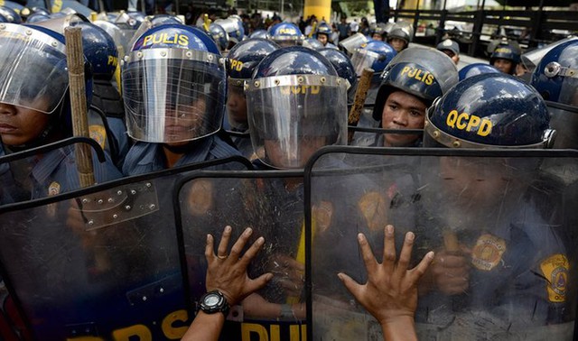 Những người biểu tình đụng độ với cảnh sát chống bạo động trên đường phố ở Manila, Philippines.