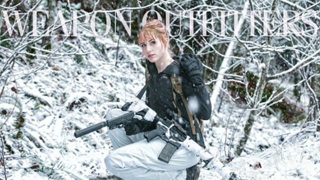 Người mẫu xinh đẹp với khẩu súng lục gắn ống giảm thanh và súng trường ngụy trang hòa lẫn với màu trắng của tuyết.