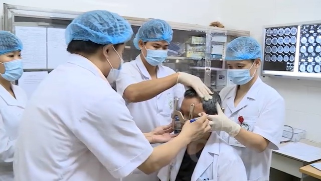 PGS Đỗ Quốc Hùng trong một buổi được các đồng nghiệp ở Bệnh viện Bạch Mai điều trị chống lại căn bệnh ung thư quái ác. Ảnh: VTV.