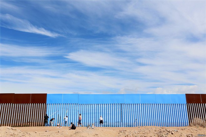Những người tình nguyện sơn màu xanh da trời cho hàng rào biên giới giữa Mỹ và Mexico tại khu vực Mexicali, Mexico.