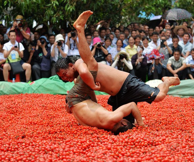 Người dân vật trong bể đầy cà chua trong lễ hội mừng được mùa tại khu tự trị Choang Quảng Tây, Trung Quốc.