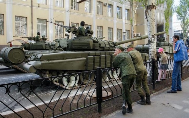 Người dân đứng dọc đường phố xem lực lượng ly khai thân Nga luyện tập chuẩn bị cho lễ duyệt binh mừng ngày Chiến thắng tại Donetsk, Ukraine.