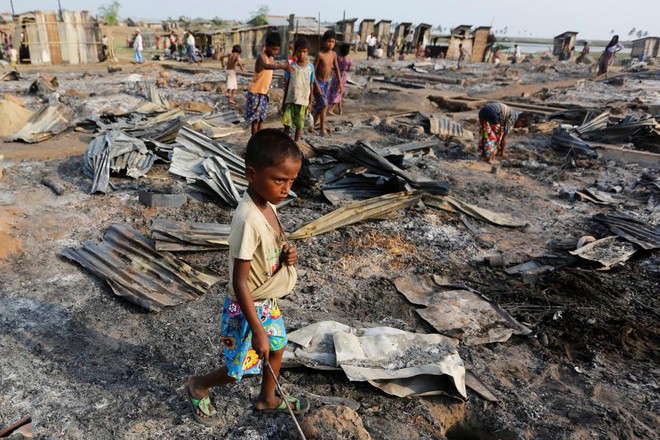 Trẻ em chơi giữa những gì còn sót lại sau khi hỏa hoạn thiêu rui các ngôi nhà tạm tại trại tị nạn dành cho người Hồi giáo Rohingya ở Rakhine, Myanmar.