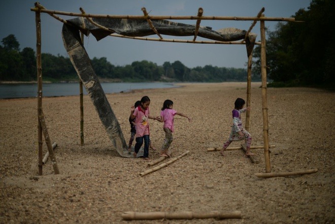 Trẻ em chơi trên bờ sông Pahang cạn khô nước trong một ngày nắng nóng ở Termerloh, Malaysia.