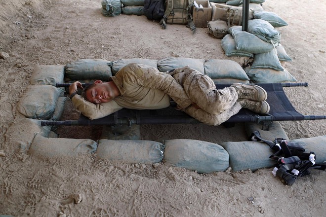 
Một anh lính thủy quân lục chiến Mỹ tranh thủ nghỉ ngơi trong bóng râm tại tiền đồn ở Kunjak, tỉnh Helmand, Afghanistan ngày 20/10/2010.
