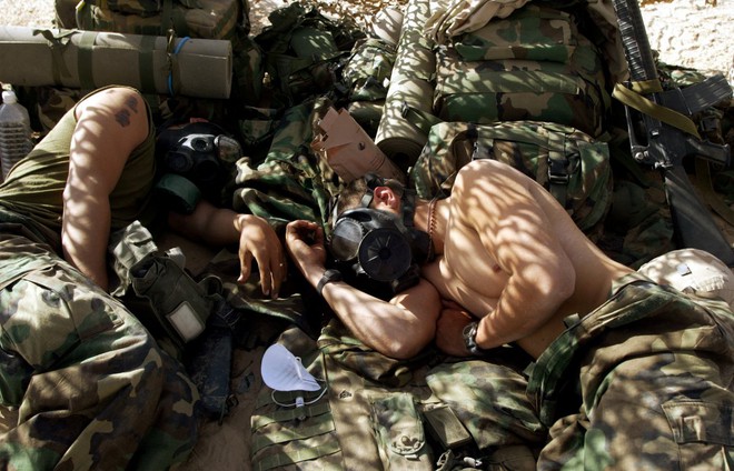 
Hai lính thủy đánh bộ Mỹ phải đeo mặt nạ phòng độc khi ngủ do được cảnh báo khả năng xảy ra một cuộc tấn công bằng khí gas tại địa điểm bí mật trên sa mạc Iraq ngày 28/3/2003.
