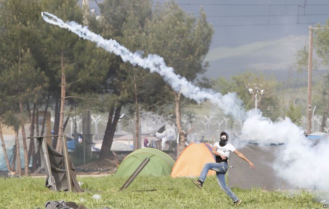 Người di cư ném lựu đạn hơi cay trả lại phía cảnh sát Macedonia trong cuộc biểu tình tại thị trấn Idomeni, Hi Lạp.