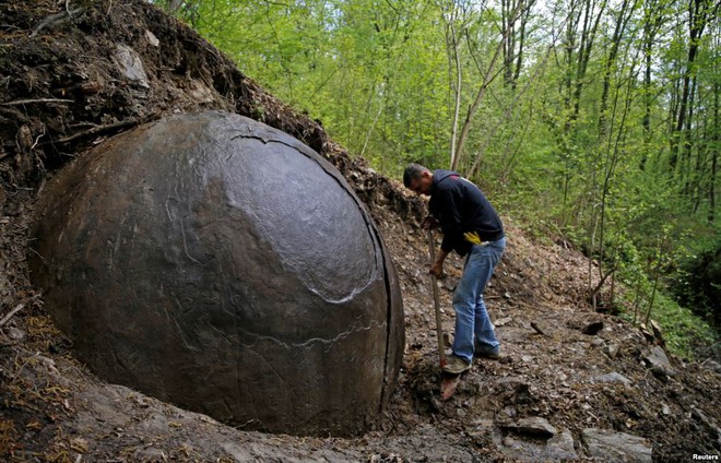 Người đàn ông đào xung quanh quả cầu đá khổng lồ ở ngôi làng Podubravlje gần Zavidovici, Bosnia&Herzegovina. Nó có đường kính 3,3m và nặng 35 tấn.