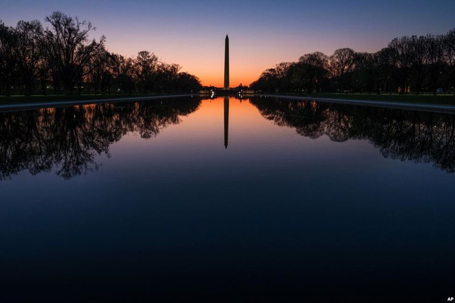 Đài tưởng niệm Washington in bóng xuống mặt hồ phẳng lặng lúc bình minh tại thành phố Washington, Mỹ.