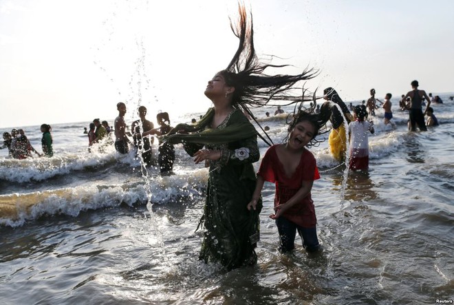 Các bé gái chơi đùa trên bãi biển trong một ngày nắng nóng ở thành phố Mumbai, Ấn Độ.