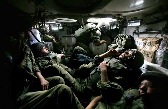 
Nhóm binh sĩ Israel tận hưởng giấc ngủ ngắn ngủi trong khoang chứa chật hẹp của chiếc xe bọc thép chở quân khi tham gia chiến dịch quân sự tại phía bắc dải Gaza ngày 7/7/2006.
