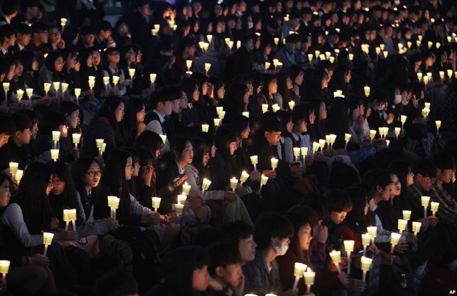 
Học sinh trung học thắp nến cầu nguyện cho các nạn nhân thiệt mạng trong thảm họa chìm phà Sewol cách đây 2 năm tại Ansan, Hàn Quốc.
