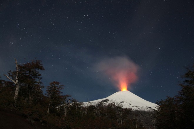 
Dung nham phun trào trong đêm tối từ miệng núi lửa Villarica ở Villarica, Chile.
