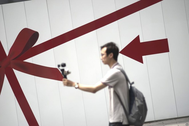 Người đàn ông chụp ảnh tự sướng tại khu phố mua sắm Ginza ở Tokyo, Nhật Bản.