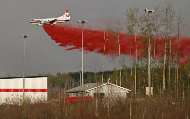 Máy bay thả hóa chất chống cháy để cố gắng dập tắt cháy rừng gần thành phố Fort McMurray, Alberta, Canada.