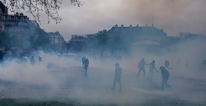 Cảnh sát chống bạo động bắn đạn hơi cay để giải tán những người biểu tình phản đối cải cách luật lao động của chính phủ ở thành phố Paris, Pháp.