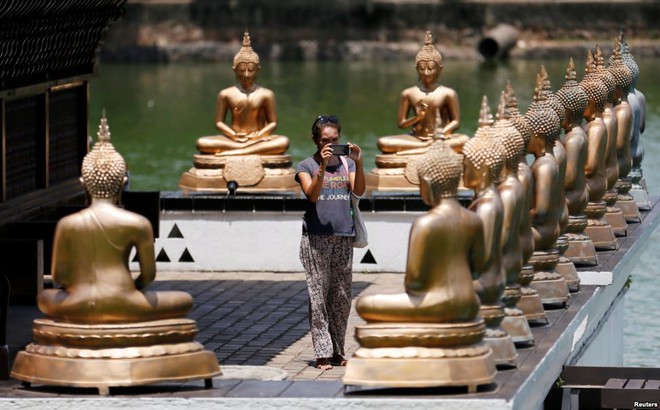 Du khách chụp ảnh các tượng phật trong một ngôi chùa ở thành phố Colombo, Sri Lanka.