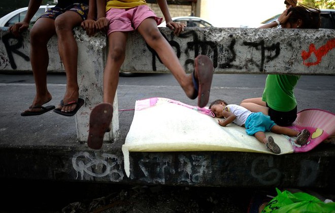 Em bé ngủ ngay trên cầu tại một khu ổ chuột ở thành phố Manila, Philippines.