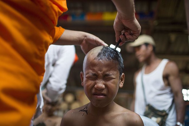 Cậu bé được cạo tóc để làm sư tiểu tại một ngôi chùa ở thành phố Wat Supan Rangsri, Thái Lan.