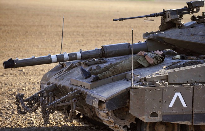 
Là thứ vũ khí đáng sợ trên chiến trường nhưng đôi lúc, những chiếc xe tăng lại trở thành chiếc giường nâng niu giấc ngủ cho người lính. Ảnh chụp tại vị trí gần khu vực Kissufim, ngay ngoài trung tâm dải Gaza ngày 11/5/2008.
