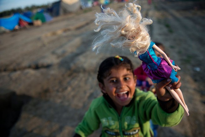 Bé gái chơi đùa cùng búp bê tại khu trại dành cho người di cư ở thị trấn Idomeni, Hy Lạp.