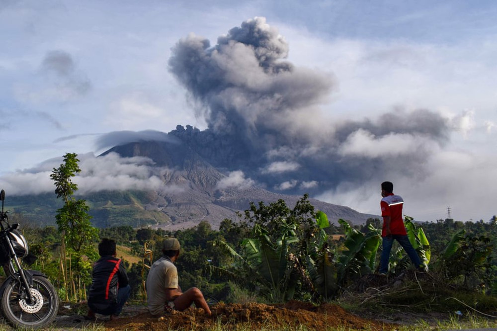 24h qua ảnh: Người dân nhìn núi lửa phun trào dữ dội ở Indonesia - Ảnh 2.