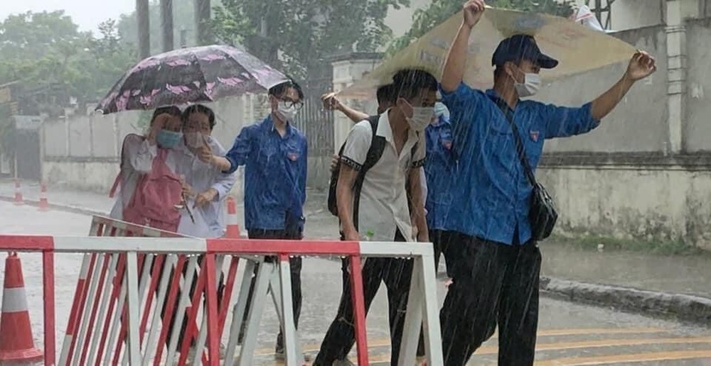 Chàng trai tình nguyện che ô cho các sĩ tử tránh cơn mưa bất ngờ, danh tính khiến dân mạng phát sốt - Ảnh 2.