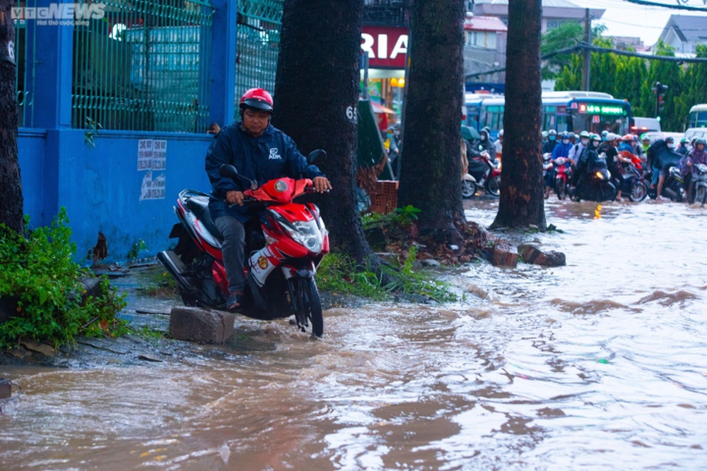 Người dân TP.HCM bì bõm lội nước về nhà sau cơn mưa lớn kéo dài hàng giờ - Ảnh 4.