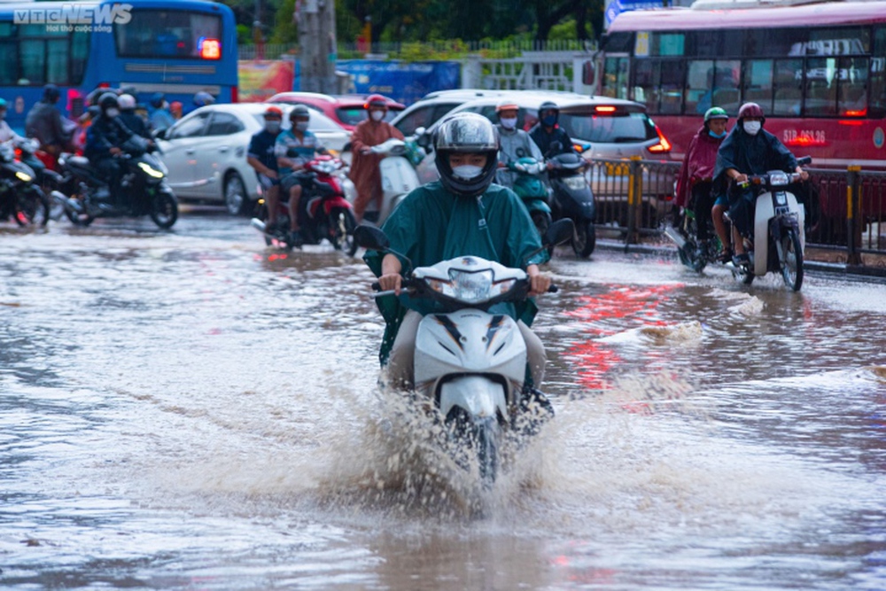 Người dân TP.HCM bì bõm lội nước về nhà sau cơn mưa lớn kéo dài hàng giờ - Ảnh 1.
